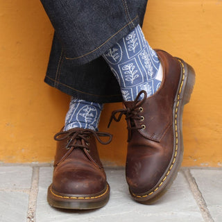 woman wearing linear floral cotton socks against a yellow wall 