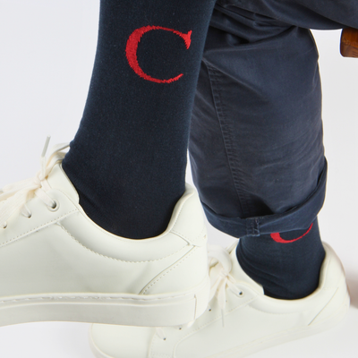 'C' letter socks worn with navy trousers and white trainers