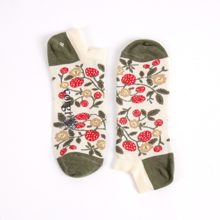 Pair of trainer length socks with red floral patterns and strawberrys on a beige background