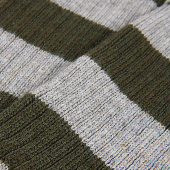 Close-up of a textured fabric with green, grey, and white stripes.