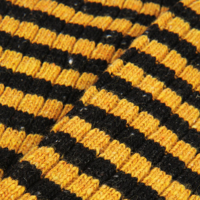 Close-up of a textured surface with black and yellow striped pattern
