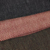 Close-up of a textured fabric with a herringbone pattern, featuring a dark gray and red color scheme.