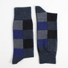 Pair of checkered socks with blue, gray, and black pattern on a white background