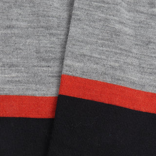 Close-up of a fabric with gray,orange and navy stripes.