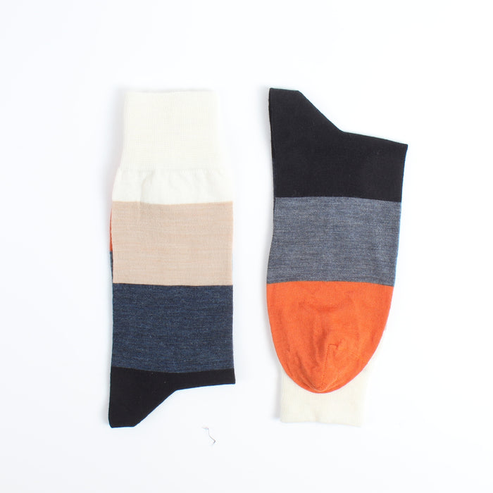 Two colourful socks in beige,blue, navy and orange toe photographed on a white background