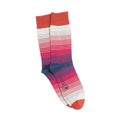 Colourful tones of red used to create a pair of striped socks photographed on a white background