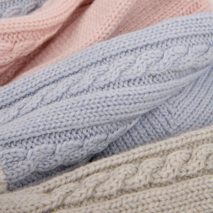 Close-up of stacked knitted socks in pink, blue, and silver.

