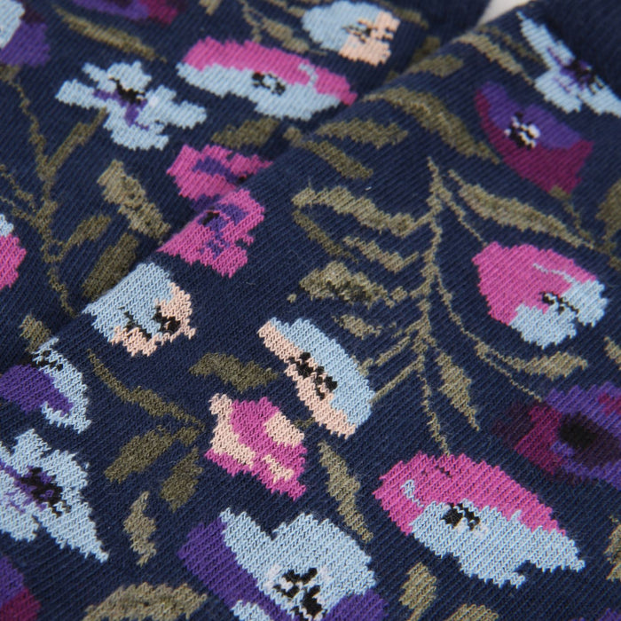 Close-up of a floral patterned fabric with pink, purple, and blue flowers on a dark background.
