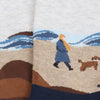 Socks with a design of a person and dog on a beach.