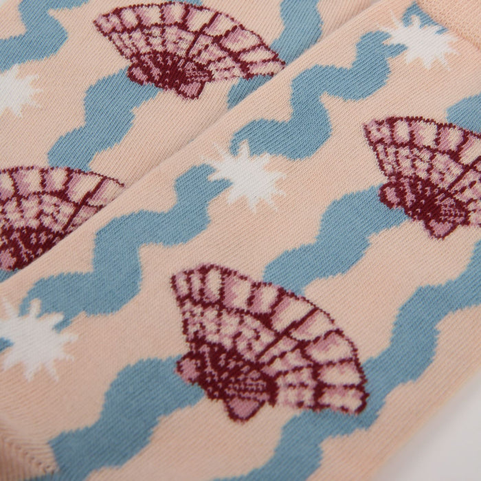 Close-up of fabric with shell and wave pattern on a pink background