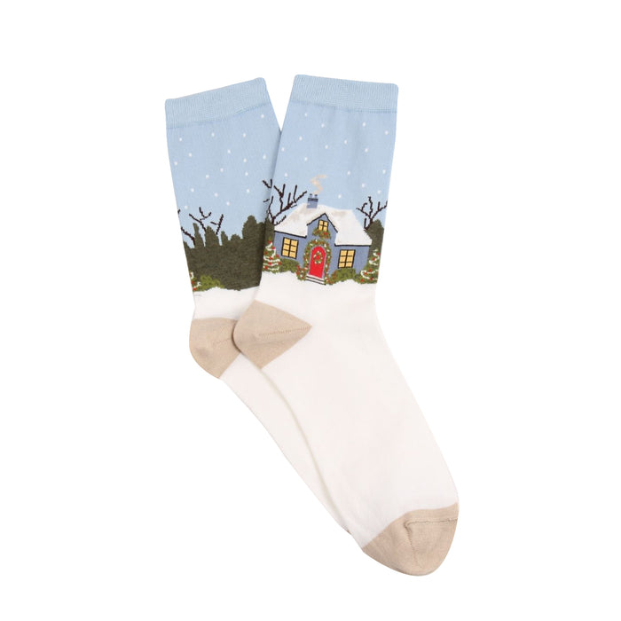 Sock with a winter scene of a house and trees on a light blue background
