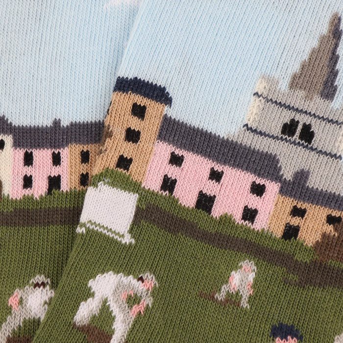 AClose up of a pair of patterned cotton socks featuring a cricket scene with players on a green field, designed for children.