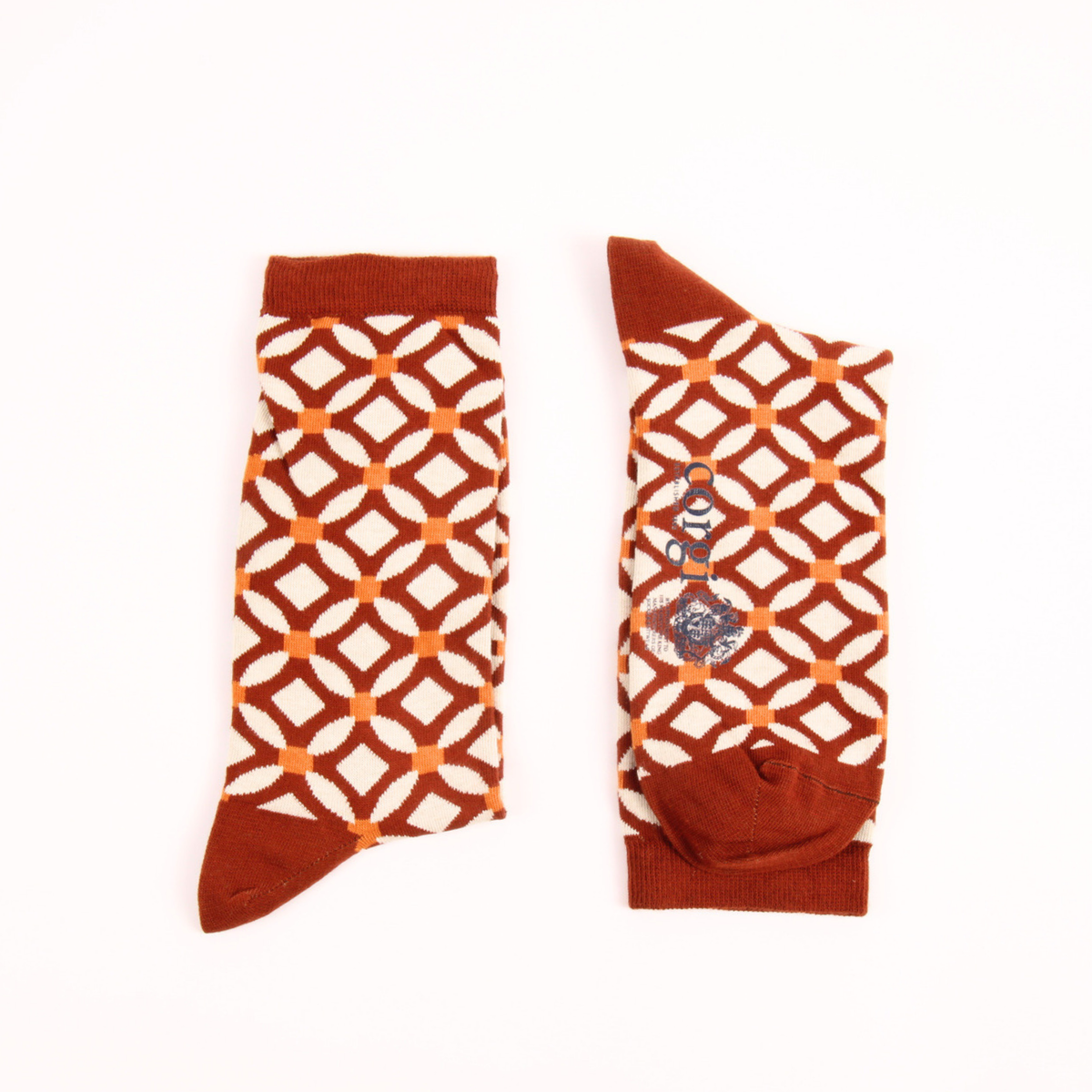 A pair of crew socks with a rust brown and white geometric lattice pattern, displayed flat against a plain white background.