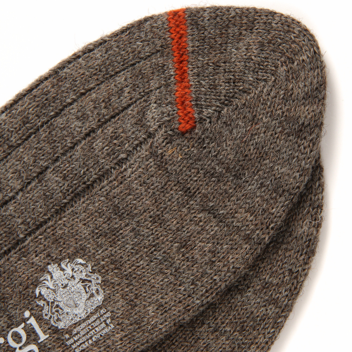 Close-up of a brown knit sock with a single orange stripe near the toe and a white embroidered logo on the side, shown on a white background.