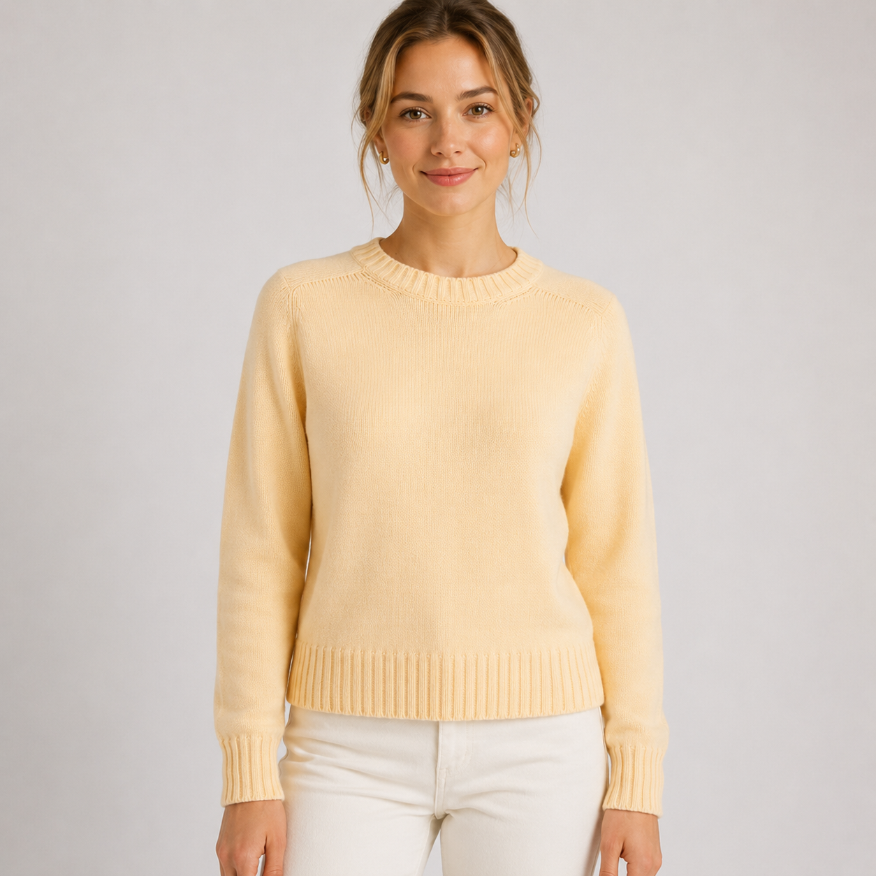Woman wearing a light yellow sweater against a plain background