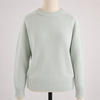 Light green sweater on a mannequin against a light pink background