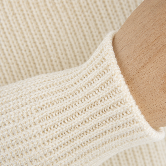 Close-up of a beige knitted sweater sleeve
