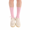 Pink socks worn with white sneakers on a white background
