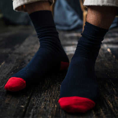 Navy socks with red toes on a wooden floor