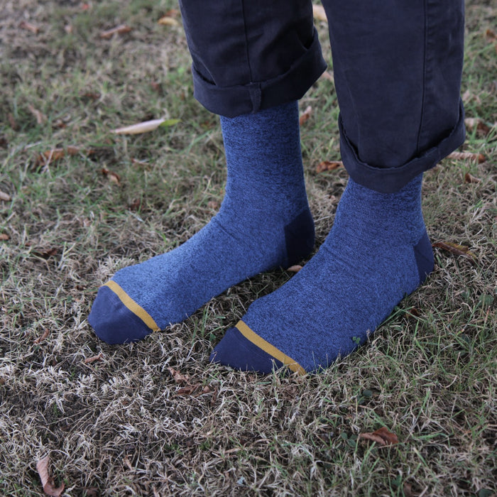 Blue socks with yellow trim worn on grass