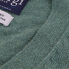 Close-up of a green fabric texture with a brand label in the corner.
