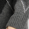 Close-up of a gray knitted sweater with a subtle pattern