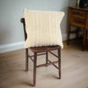 Cream Donegal Wool cushion on a wooden chair