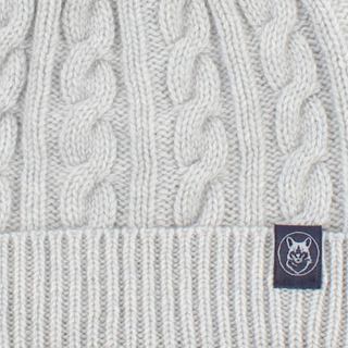 White knit beanie with a brand label on a white background