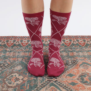 woman wearing patterned magenta socks on a patterned rug