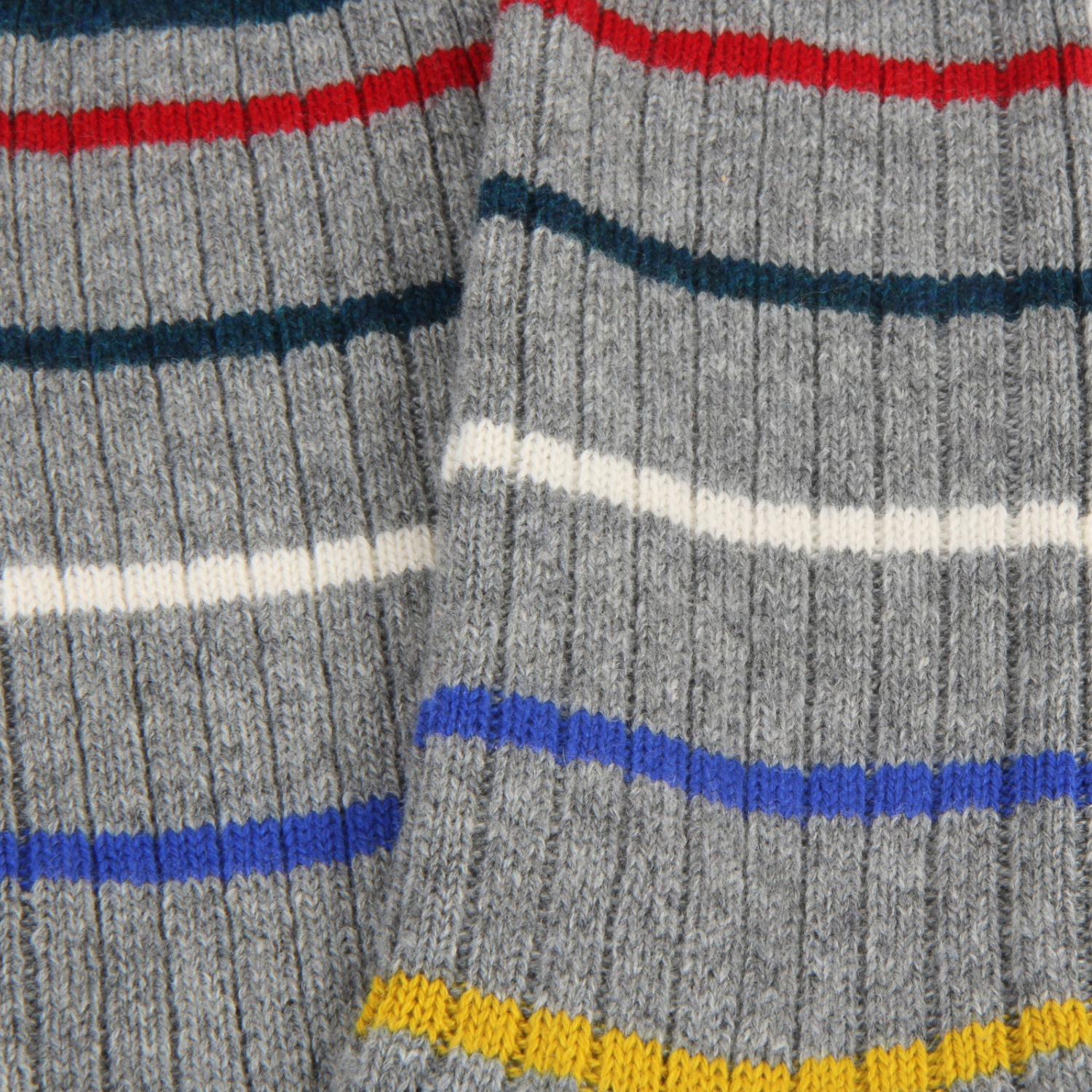 Close-up of gray socks with colorful stripes on a textured fabric background