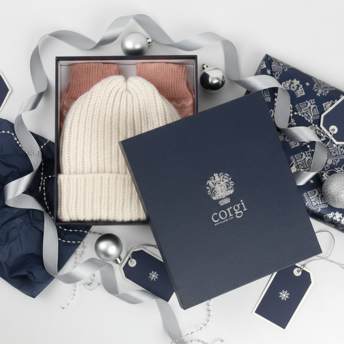 White knit beanie and pink socks in a Corgi branded box on a white background