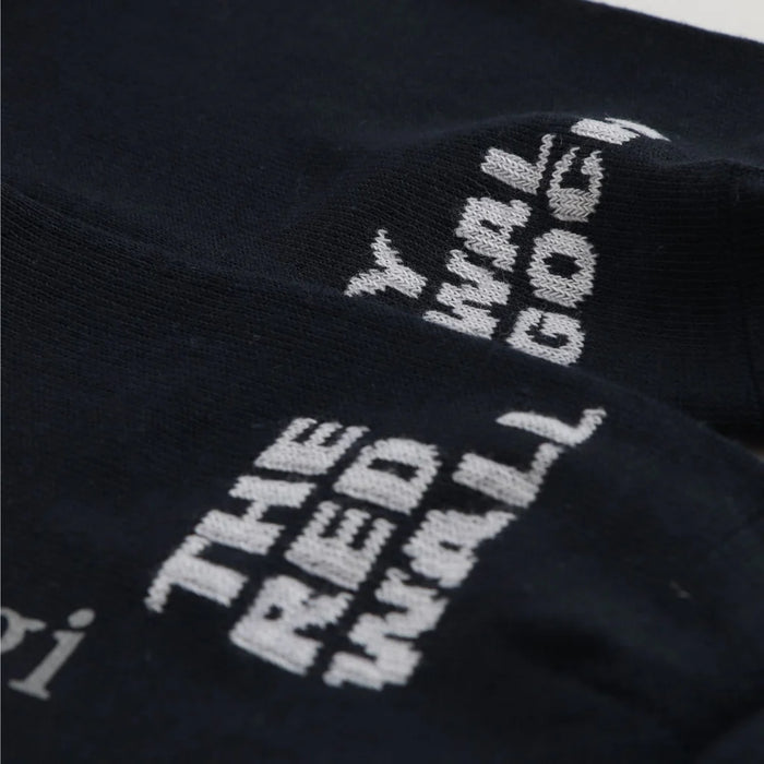 close up of kids' socks with a striped pattern in red, white, and blue colors, featuring the text 'THE RED WALL' on the foot area.