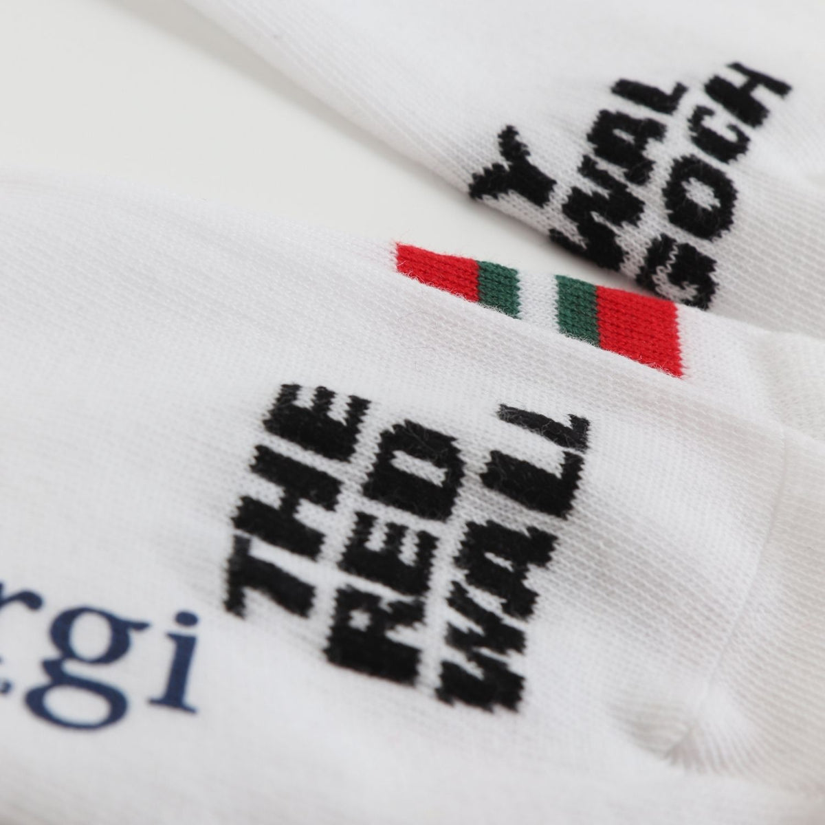 close up of white crew socks with red and green stripes on the calf, featuring text 'RED WALL' and the flag of Wales.