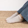 White socks worn with blue jeans on a textured surface