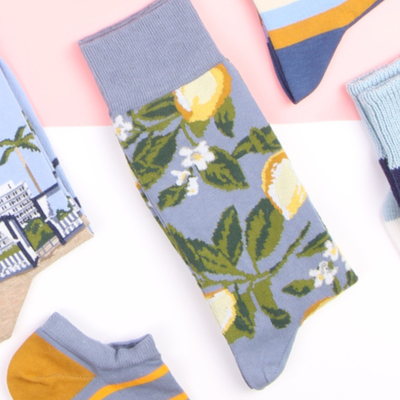 Colorful socks with lemon and leaf pattern on a white background