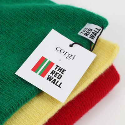 A folded scarf in green, yellow, and red with 'Corgi' and 'The Red Wall' labels.