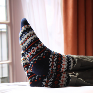 Patterned socks being worn with a blurred indoor background