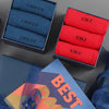 A set of personalised socks in various colors, with each box labeled with a name. The packaging includes a gift box with the word 'BEST' on it.