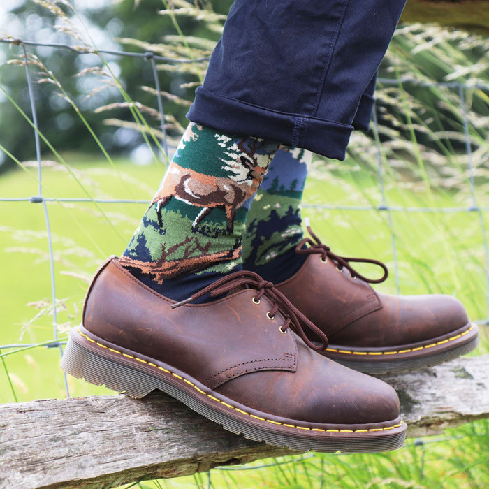 man wearing deer socks in a field 