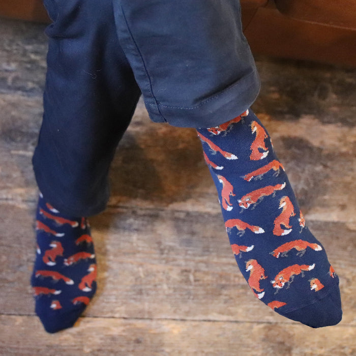 man wearing fox patterned socks on a wooden floor