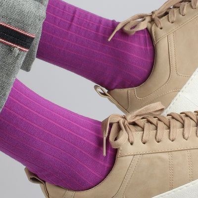 A pair of purple merino wool socks designed for men, showing the socks worn with a beige sneaker.