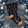 Navy socks with red nutcracker design on a wooden surface with Christmas decorations.