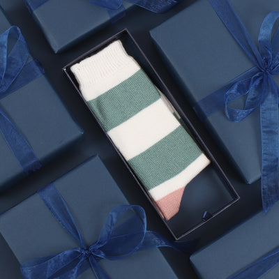 A pair of women's cashmere and cotton colour block socks with stripes in green and pink shades, and a gold toe.