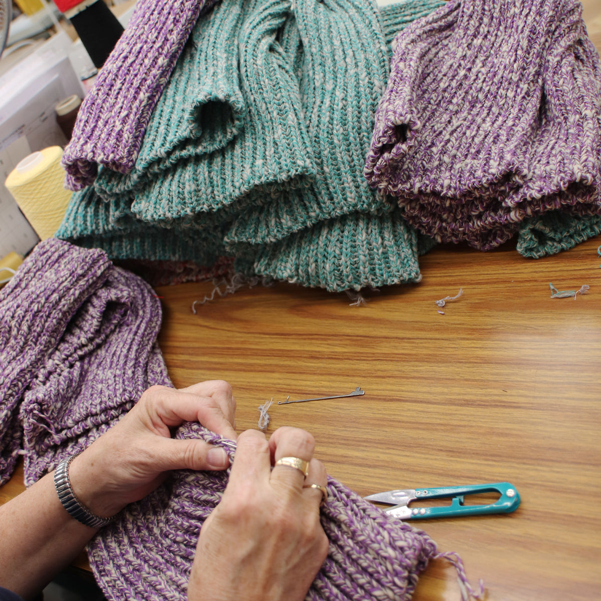 person at the factory hand finishing the cashmere blend beanies 