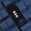 A pair of navy blue cashmere socks with a monogram pattern in a gift box.