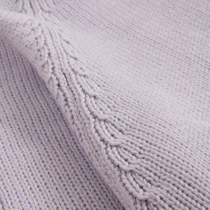 Close-up of a textured purple fabric with knit pattern
