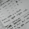Handwritten notes on a piece of paper with text and numbers.