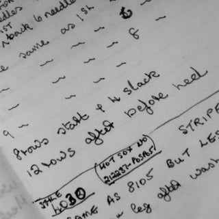 Handwritten knitting instructions on a piece of paper with text and numbers.